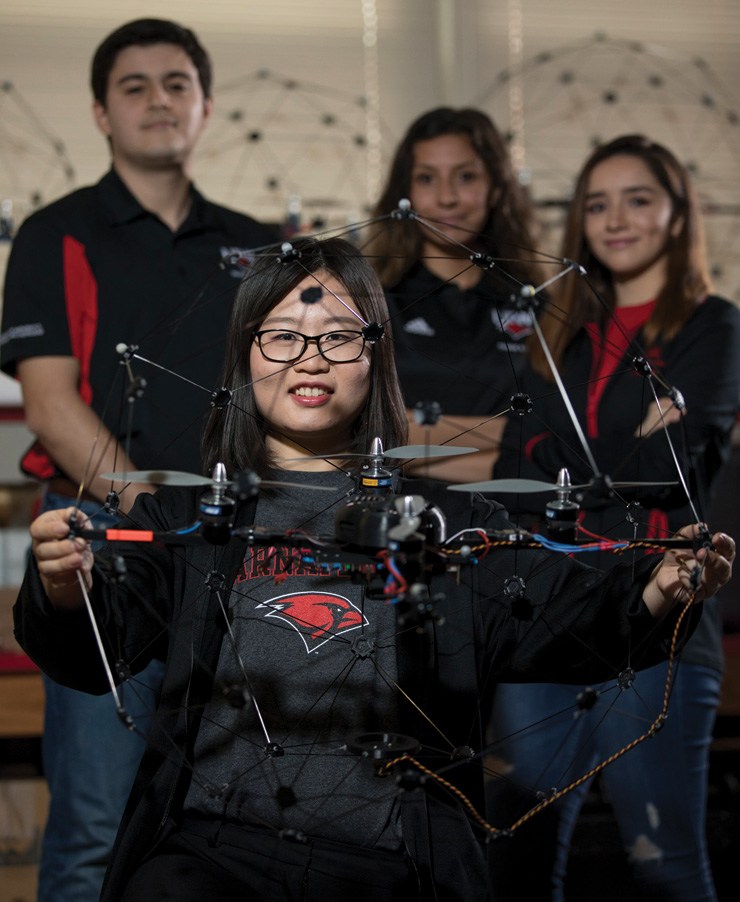 Female engineering student holding drone