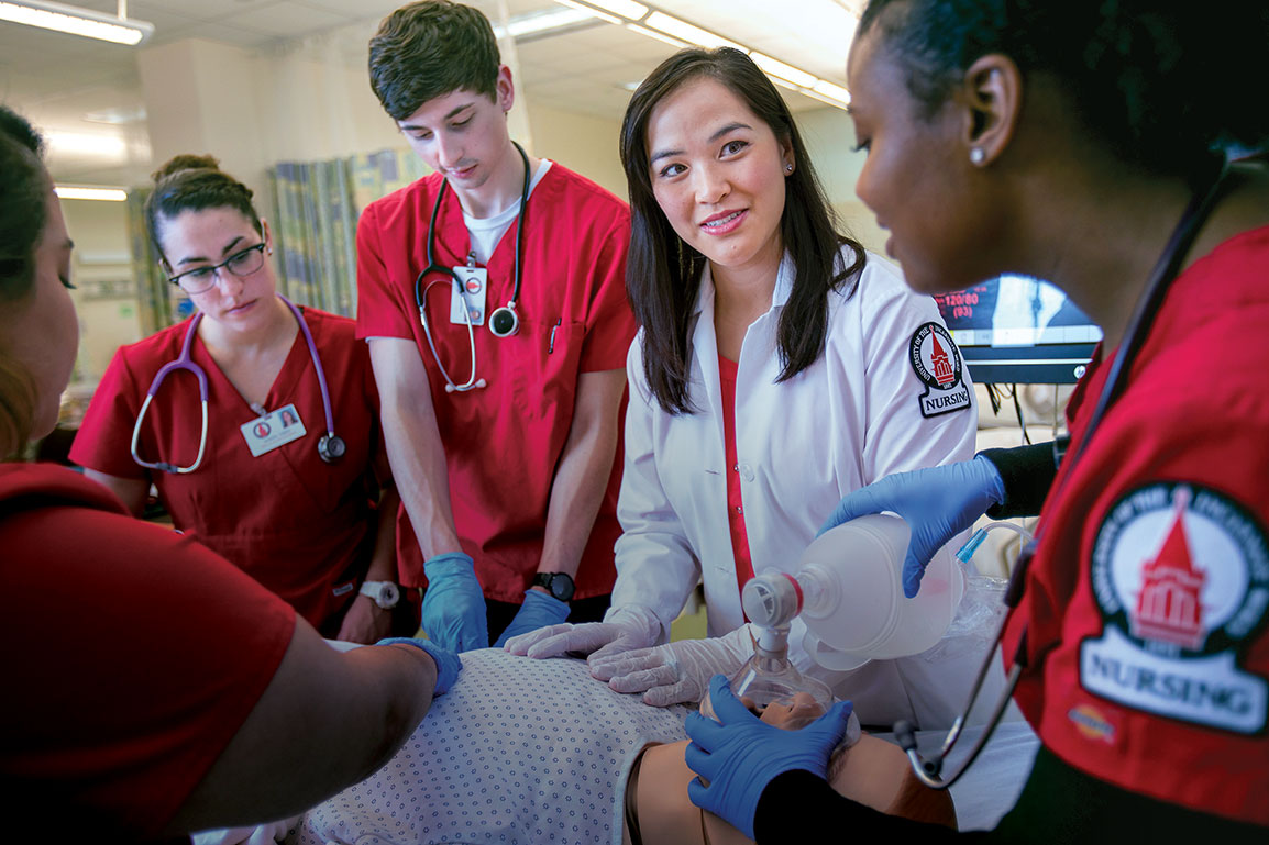 Nursing students practicing on dummy